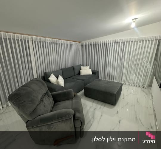 וילונות לבנים ארוכים תלויים לאורך הקיר